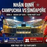 Hình ảnh bìa nhận định trận đấu Campuchia vs Singapore tại ASEAN Cup 2026, hiển thị cầu thủ hai đội và logo ThapcamTV trên nền sân Morodok Techo.
